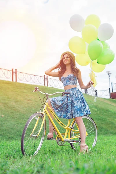 Piękna młoda kobieta jazdy na rowerze z czapką na głowie, ciesząc się czas letni — Zdjęcie stockowe