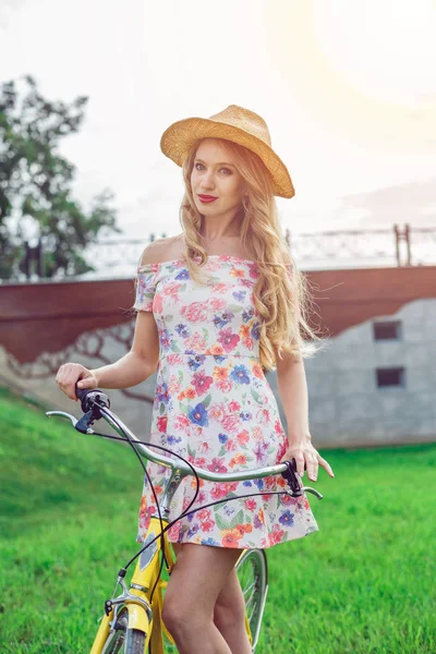 Retrato de bela menina loira andar de bicicleta no parque — Fotografia de Stock