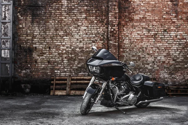 Современный черный мотоцикл стоит у кирпичной стены — стоковое фото