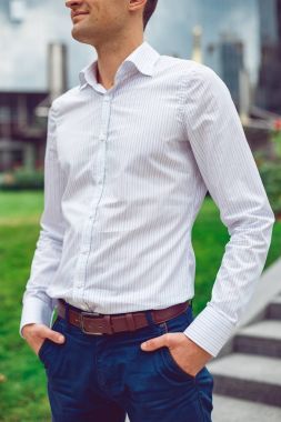 Beyaz gömlek ve Mavi pantolon sokakta poz giyen genç adam