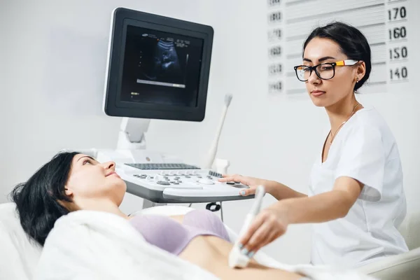 Dokter de patiënt maakt vrouwen abdominale echografie. — Stockfoto