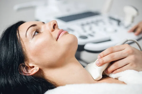 Vista da vicino di una giovane donna sottoposta a ecografia in una clinica moderna — Foto Stock