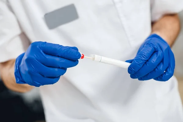 Visão de perto do esfregaço de DNA da saliva nas mãos dos médicos — Fotografia de Stock