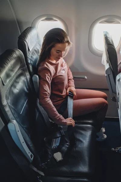 Mädchen wird im Flugzeug angeschnallt — Stockfoto