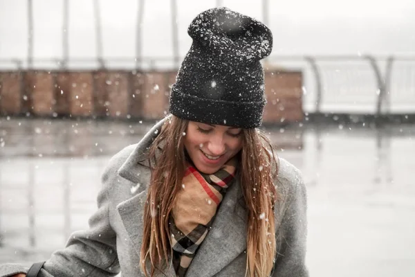 Portret van een meisje in een hoed en een grijze jas. — Stockfoto