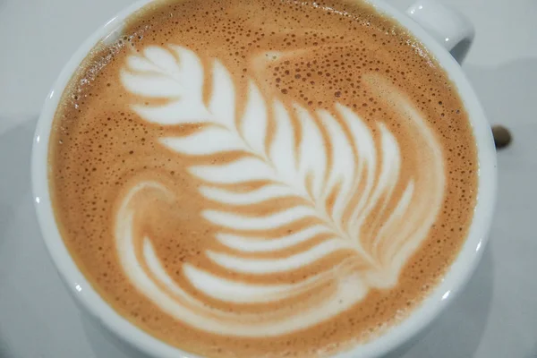 Una taza de café y un patrón en espuma de leche . —  Fotos de Stock