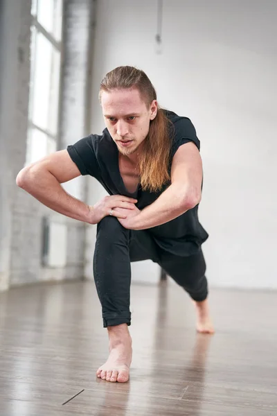 Joven ajuste hombre estiramiento piernas haciendo adelante embestida . — Foto de Stock