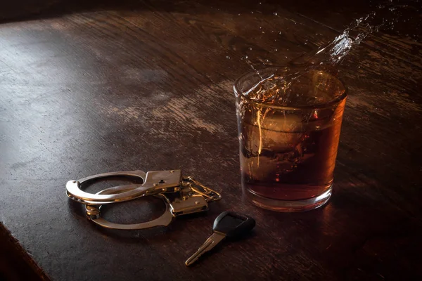 Алкогольные ключи в наручниках — стоковое фото