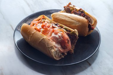 Dilimlenmiş domatesli ve bol kremalı peynirli peynirli peynirli sandviç.