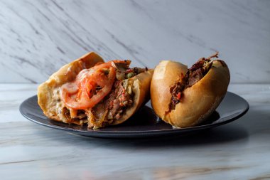 Dilimlenmiş domatesli ve bol kremalı peynirli peynirli peynirli sandviç.