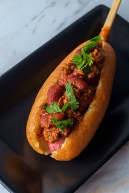 Amerikan fast-food sosislisi mermer mutfak masasında.