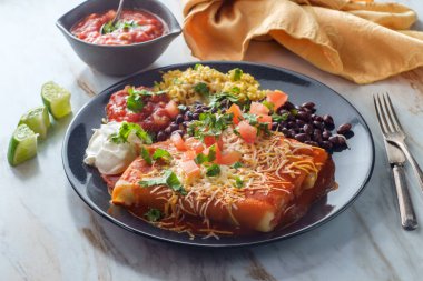 Otantik Meksika chimichanga burrito ile ekşi kremalı pirinç ve siyah fasulye.