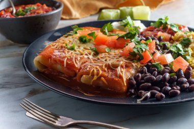 Otantik Meksika chimichanga burrito ile ekşi kremalı pirinç ve siyah fasulye.