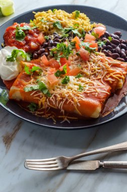 Otantik Meksika chimichanga burrito ile ekşi kremalı pirinç ve siyah fasulye.