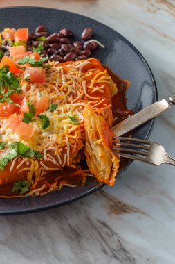 Otantik Meksika chimichanga burrito ile ekşi kremalı pirinç ve siyah fasulye.