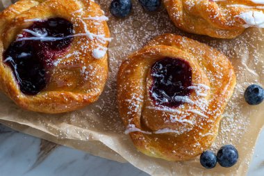 Böğürtlenli kremalı ve pudra şekerli Danimarka çörekleri.