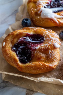 Böğürtlenli kremalı ve pudra şekerli Danimarka çörekleri.