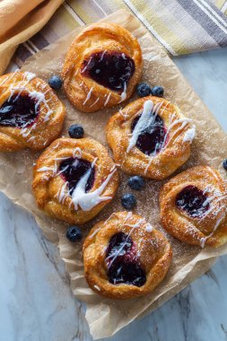 Böğürtlenli kremalı ve pudra şekerli Danimarka çörekleri.