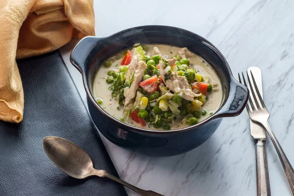 British slow cooked chicken thigh fricassee stew in white sauce with colorful vegetables