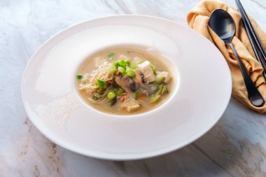 Bir kase dolusu Japon miso çorbası erişteli tofu jülyen havuç ve kabak.