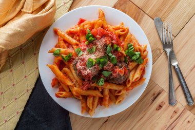 İtalyan makarna soslu makarna ve doğranmış fesleğen ve parmesan peyniri ile süslenmiş köfte.
