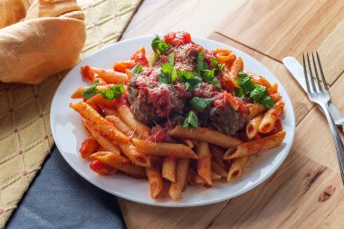 İtalyan makarna soslu makarna ve doğranmış fesleğen ve parmesan peyniri ile süslenmiş köfte.