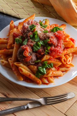 İtalyan makarna soslu makarna ve doğranmış fesleğen ve parmesan peyniri ile süslenmiş köfte.