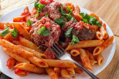 İtalyan makarna soslu makarna ve doğranmış fesleğen ve parmesan peyniri ile süslenmiş köfte.
