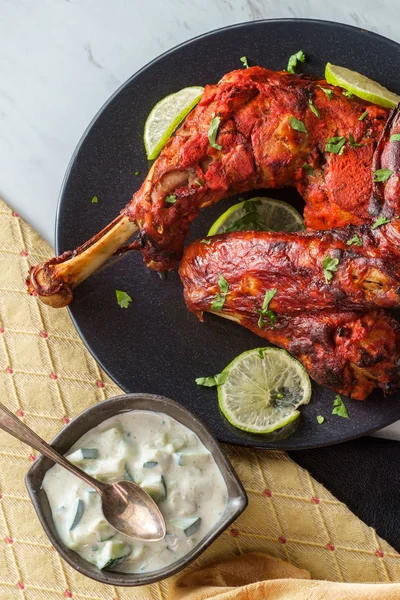 Indian cuisine spicy red Tandoori chicken with cucumber raita