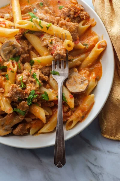 이탈리아의 파스타 보드카 토마토 소스에 소시지와 버섯을 대리석 식탁에 — 스톡 사진