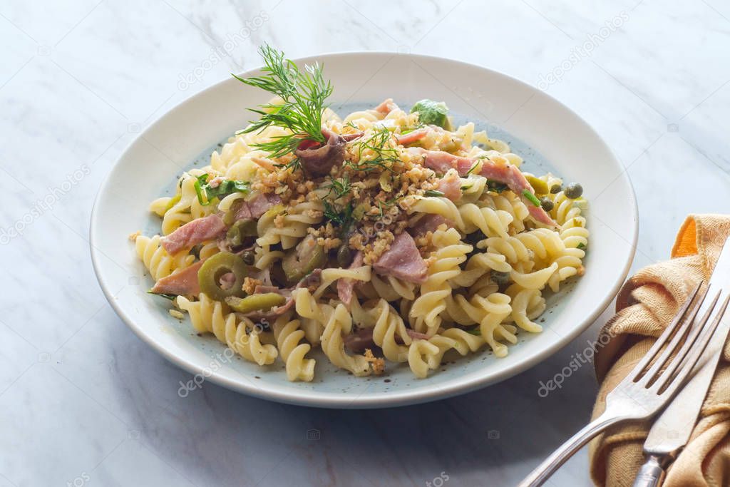 Castelvetrano olives Italian fusilli pasta mollicata with capers and prosciutto garnished with breadcrumbs in an anchovy white wine sauce