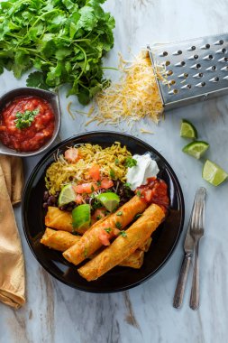 Meksika usulü taco tavuk ve peynirli taco pilav ve siyah fasulye.