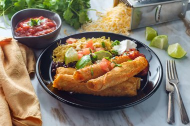 Meksika usulü taco tavuk ve peynirli taco pilav ve siyah fasulye.