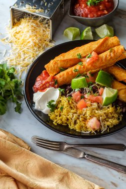 Meksika usulü taco tavuk ve peynirli taco pilav ve siyah fasulye.