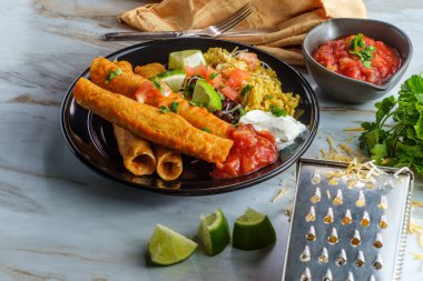 Meksika usulü taco tavuk ve peynirli taco pilav ve siyah fasulye.