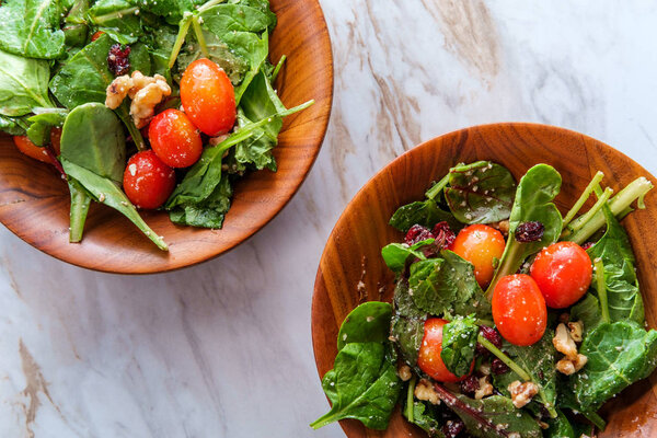 Simple baby kale walnut salad with dried cranberries and oil vinegar dressing