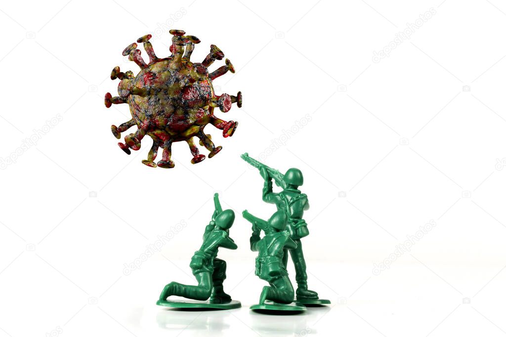 Green toy army men attack and fight off the coronavirus as metaphor for human immune system