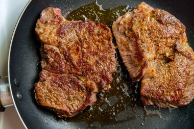 Tavada kızarmış biftek ve cızırdayan zeytinyağı.