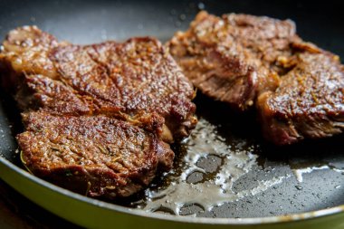 Tavada kızarmış biftek ve cızırdayan zeytinyağı.