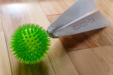 Kapalı havaalanlarının metaforu olarak COVID-19 yazan kağıt uçakla ölümcül bir koronavirüs.