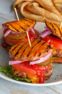 Glütensiz tatlı patates ekmeği ızgara çizburger dilimleri.