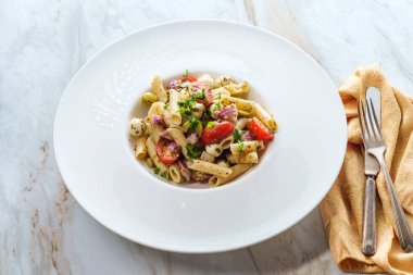 Glütensiz İtalyan pesto salatası inci mozzarella peyniri topları ve yarım kiraz domatesli.