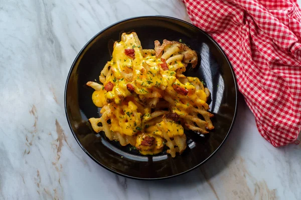Crispy waffle fries loaded with bacon and melted cheddar cheese sauce