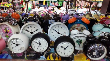 Çocuklar için güzel renkli hayvan şekilli saat hediyesi süpermarket rafındaki çalar saat kırtasiyesi ürünü. Duvarda bir sürü farklı duvar saati var. Çalar saat, kitapçıda beyaz saat. Kapat ve seçici odaklan.