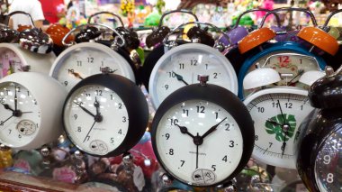 Çocuklar için güzel renkli hayvan şekilli saat hediyesi süpermarket rafındaki çalar saat kırtasiyesi ürünü. Duvarda bir sürü farklı duvar saati var. Çalar saat, kitapçıda beyaz saat. Kapat ve seçici odaklan.
