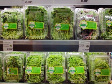 Süpermarkette raflardaki plastik kaplarda çeşitli otlar ve yapraklar