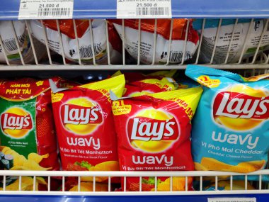 Pringles cipsi patates cipsi sağlıksız atıştırmalık, tuzlu patates kızartması süpermarket rafında leziz çıtır cipsler. Renkli seçilmiş çerez paketlerinin görüntüsü Fast Food ve şekerleri renkli paketlemede, çocuklar için yerel büfede satılmaktadır.