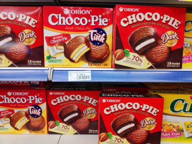 Saigon / Vietnam - July 01 2019: Boxed cakes and biscuits on supermarket shelves. Assorted boxes of branded cake flours. A grocery store shelf with baking: Orion Choco-Pie, Solite, Goute, LU, Custas