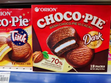 Saigon / Vietnam - July 01 2019: Boxed cakes and biscuits on supermarket shelves. Assorted boxes of branded cake flours. A grocery store shelf with baking: Orion Choco-Pie, Solite, Goute, LU, Custas