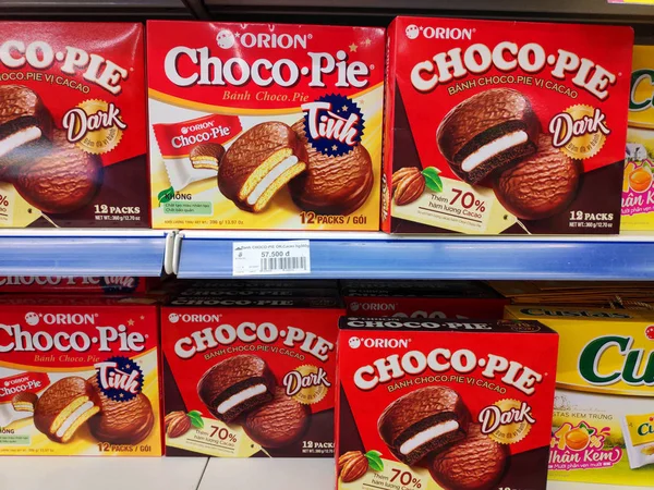Saigon / Vietnam - July 01 2019: Boxed cakes and biscuits on supermarket shelves. Assorted boxes of branded cake flours. A grocery store shelf with baking: Orion Choco-Pie, Solite, Goute, LU, Custas